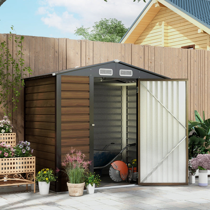 Brown metal shed beside a fence with the door open, showing a wheelbarrow and disc cutter inside