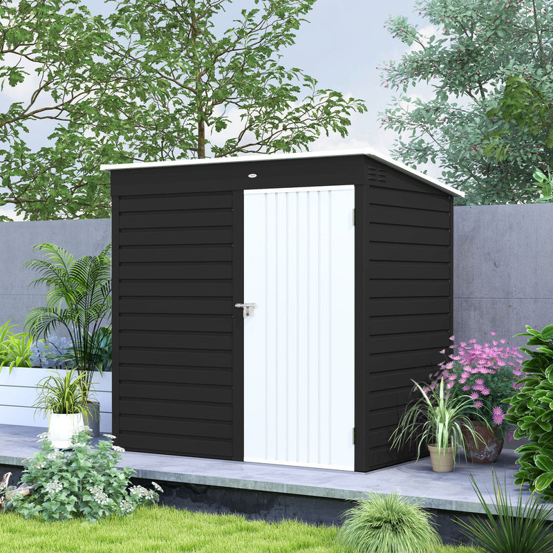 Dark grey metal shed with the white door closed, standing beside garden planting