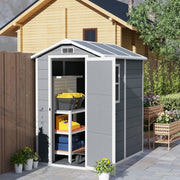 Plastic garden shed beside a timber cabin with the door open showing shelves of tools