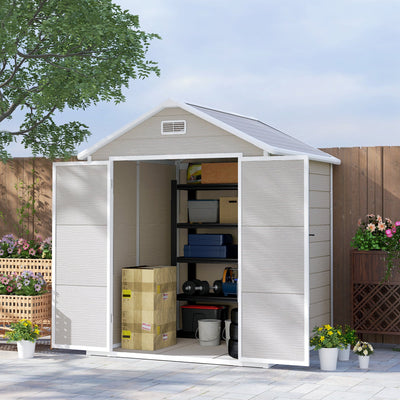 Plastic garden shed on a patio with both doors open showing shelving and boxes inside