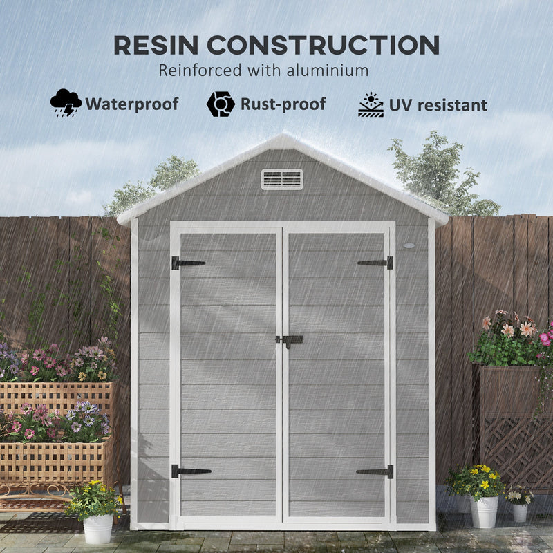 Apex roof shed standing in rain, labelled resin construction reinforced with aluminium