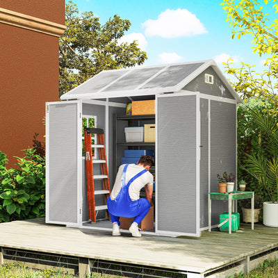 6x6ft grey shed on decking with doors open and a man kneeling beside a ladder and boxes