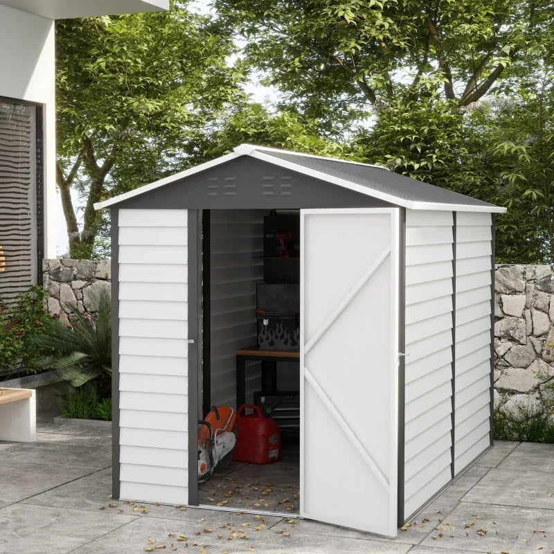 White 6x9ft metal garden shed in a garden with the door open showing stored tools