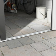 Close-up of the shed doorway threshold with a bicycle and paint tins inside