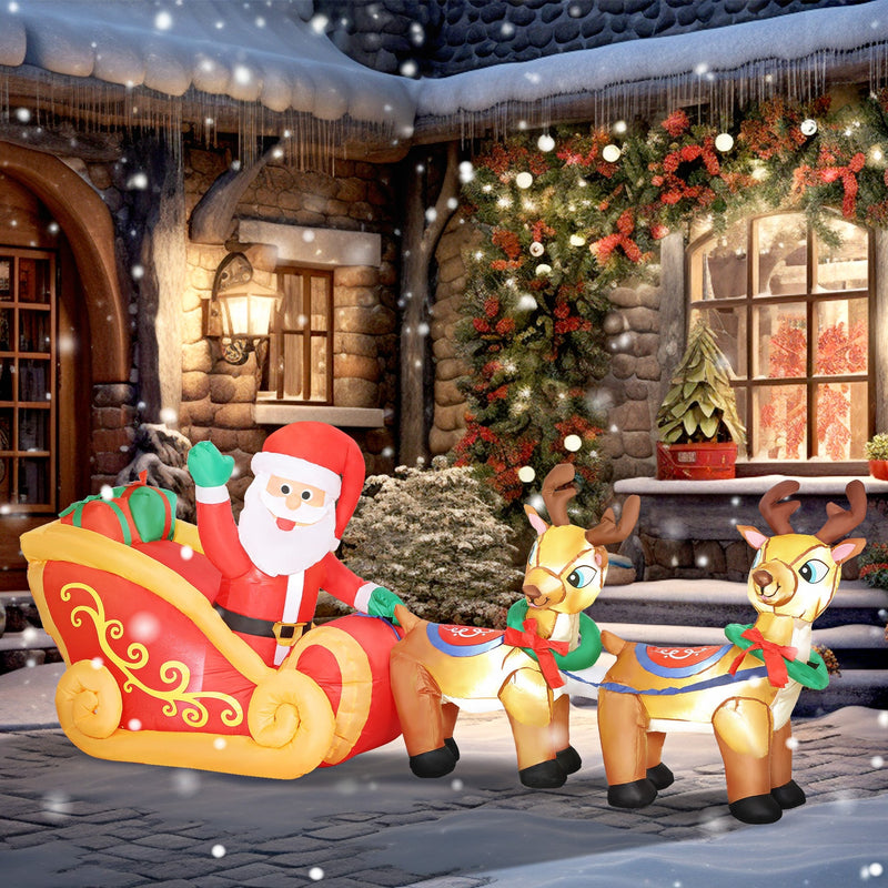 Inflatable Santa sleigh and reindeer in front of a snowy stone house
