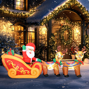 Inflatable Santa sleigh and reindeer lit up beside a decorated porch at night