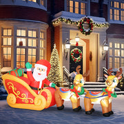 Inflatable Santa sleigh and reindeer in front of a house with a wreath and Christmas tree