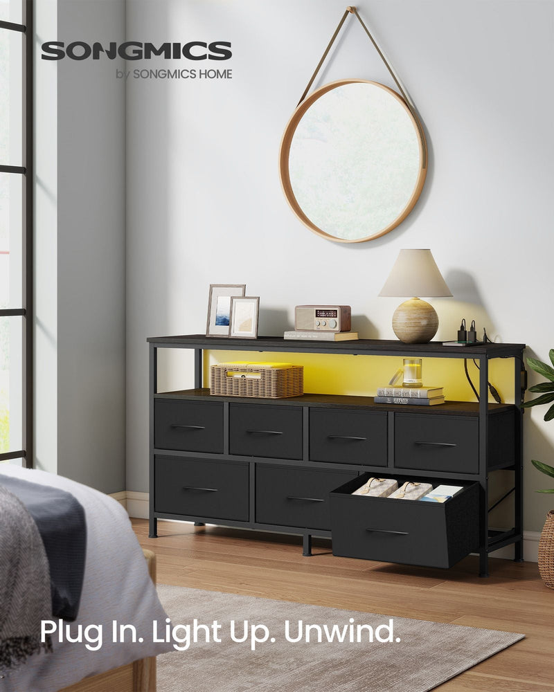 7 drawer chest of drawers in a bedroom with yellow LED lights, a round mirror above and one drawer open