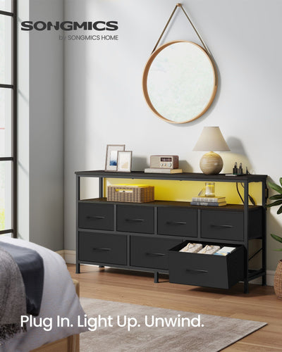 7 drawer chest of drawers in a bedroom with yellow LED lights, a round mirror above and one drawer open
