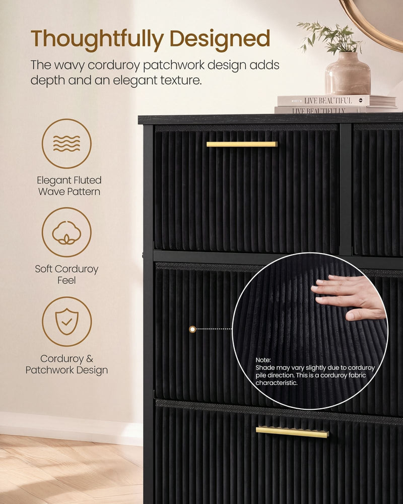 Close-up of fluted black corduroy drawer fronts with a gold handle and a hand on the fabric