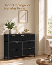Black corduroy chest of drawers styled in a living room beside a sunny window