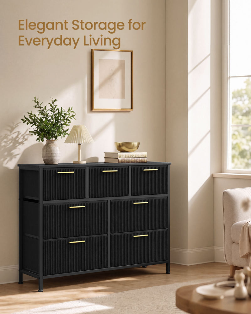 Black corduroy chest of drawers styled in a living room beside a sunny window