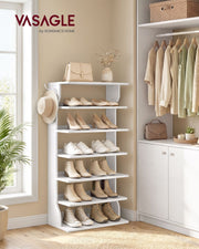 Slim white shoe rack filled with shoes beside a wardrobe, with a hat on the side hook