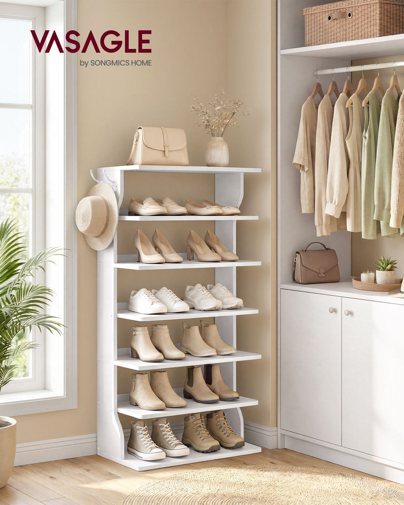Slim white shoe rack filled with shoes beside a wardrobe, with a hat on the side hook