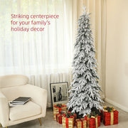 Slim snowy tree beside an armchair with wrapped presents