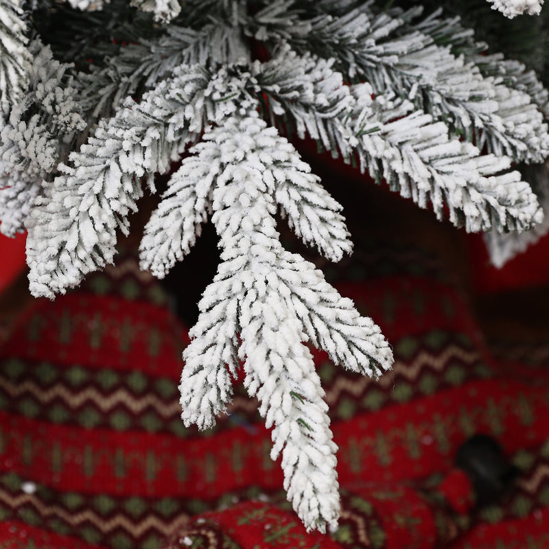 Macro of snow-flocked branch tips against red fabric