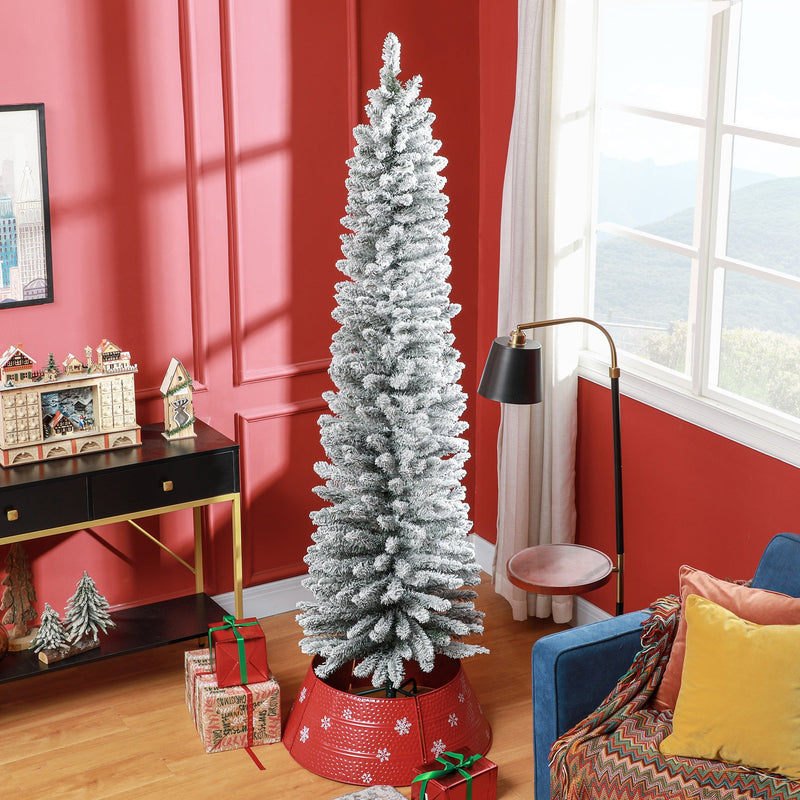 Snow-flocked 7ft pencil Christmas tree in a red living room with a red tree skirt and gifts