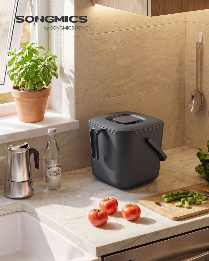 Grey compost bin on a kitchen worktop beside fresh vegetables