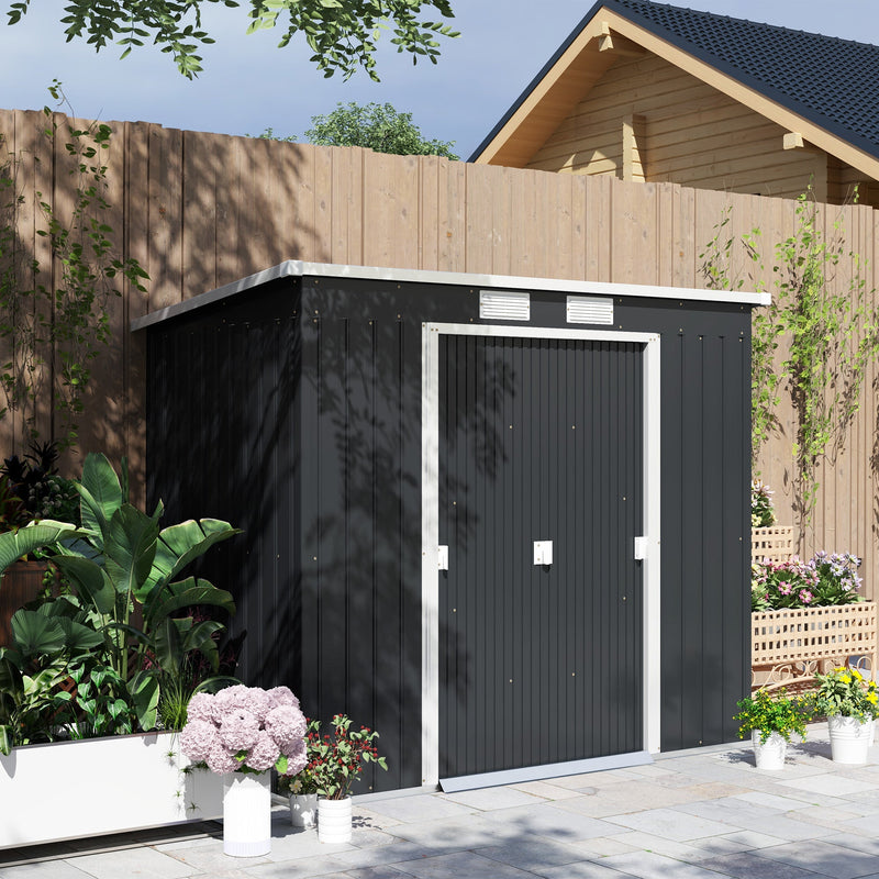 Dark grey pent roof garden shed standing against a wooden fence with the doors closed