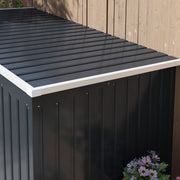 Close-up of the sloping pent roof edge and ribbed dark grey wall panels