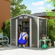 Man loading a box into the open 7x4ft apex metal shed with shelving inside