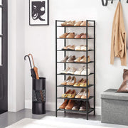 The shoe rack in a white hallway holding 16 pairs of shoes, beside an umbrella stand and storage bench
