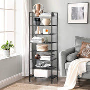The same rack used as living room shelving, holding books, a plant pot, vases and a woven basket
