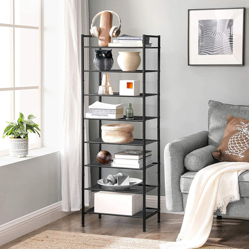 The same rack used as living room shelving, holding books, a plant pot, vases and a woven basket