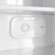 Close-up of the thermostat dial inside the white mini freezer