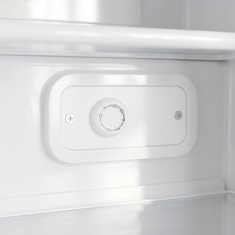 Close-up of the thermostat dial inside the white mini freezer