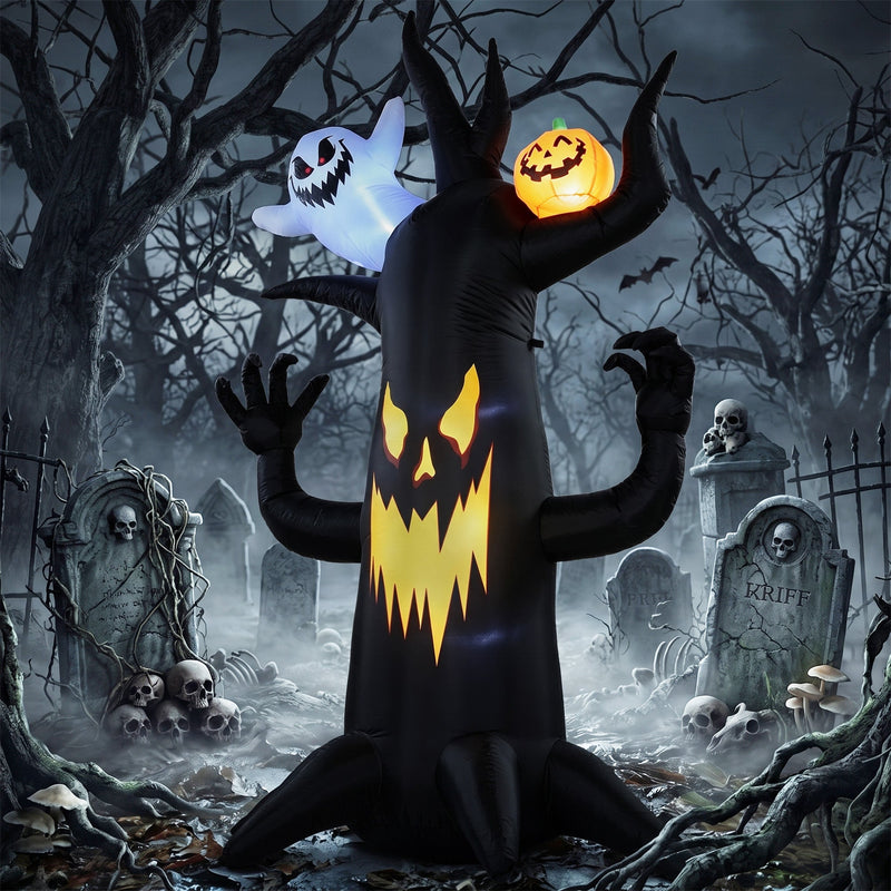 8 ft spooky tree inflatable lit up at night in a graveyard scene with skulls