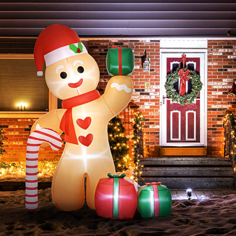 Glowing gingerbread man inflatable in front of a brick house with a wreath and lights at night