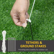 Hand tying a white tether rope to a ground stake in grass with tethers and ground stakes callout