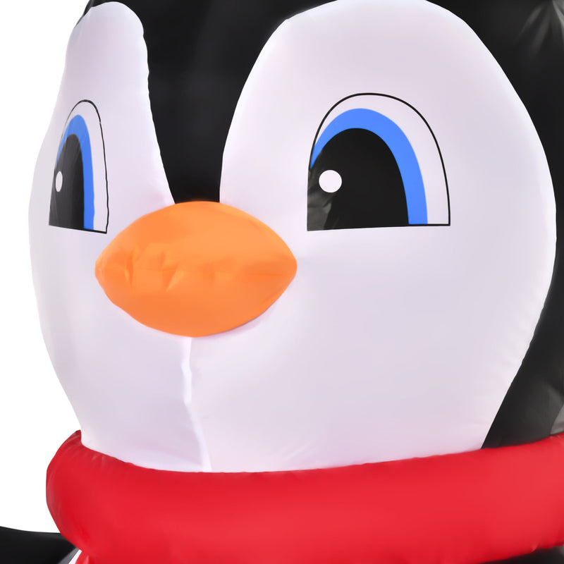 Close-up of the penguin's face with orange beak and red scarf