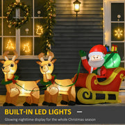 Inflatable Santa and two reindeer glowing with built-in LED lights in front of a dark house