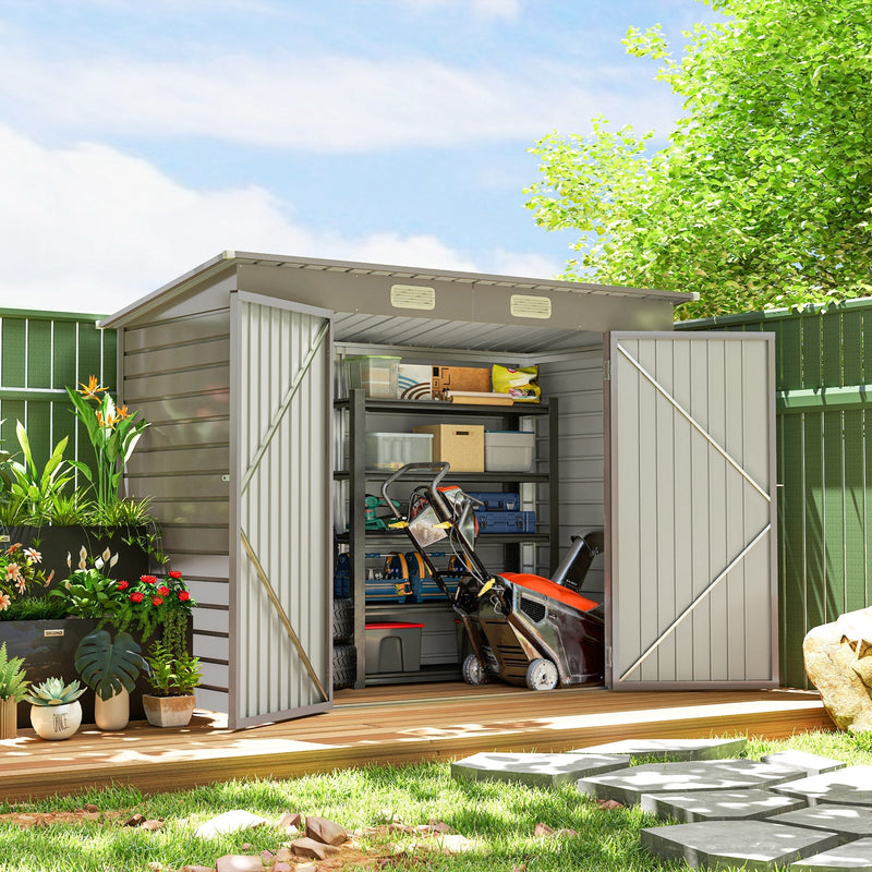 Metal shed in a garden with both doors open showing shelving, a mower and boxed tools