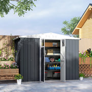 Dark grey shed on a patio with both doors open showing boxes and tools on shelving inside