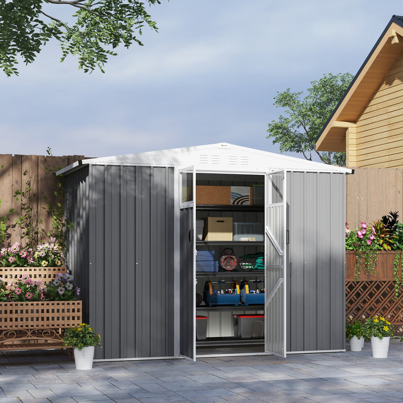 Light grey shed on a patio with doors open showing storage boxes and tools on shelving
