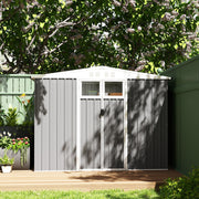 Light grey shed closed on garden decking against a dark green fence in dappled sunlight