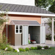 Grey shed beside a house with both doors open showing a mower and garden tools