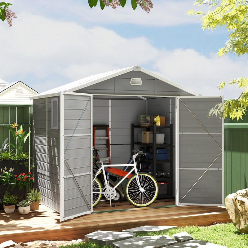 Light grey plastic shed on decking with doors open, holding a bike and a loaded shelving unit
