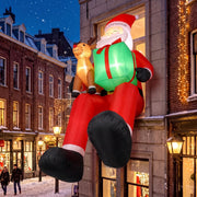 Inflatable Santa with dangling legs against a brick shopfront at night