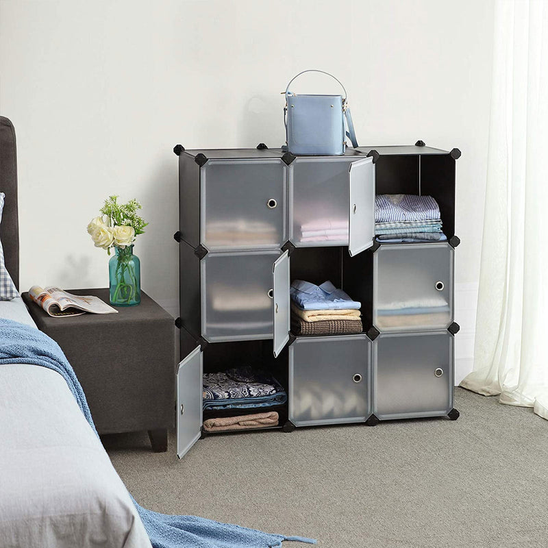 Cabinet doors open in a bedroom showing folded clothes stored inside