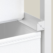 Close-up of a white fabric drawer sitting on its metal support rail inside the frame