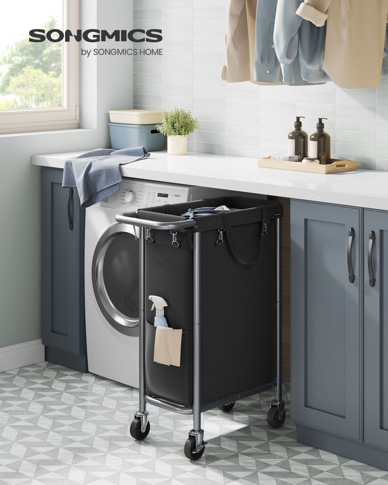 Songmics branded laundry basket beside a washing machine in a laundry room
