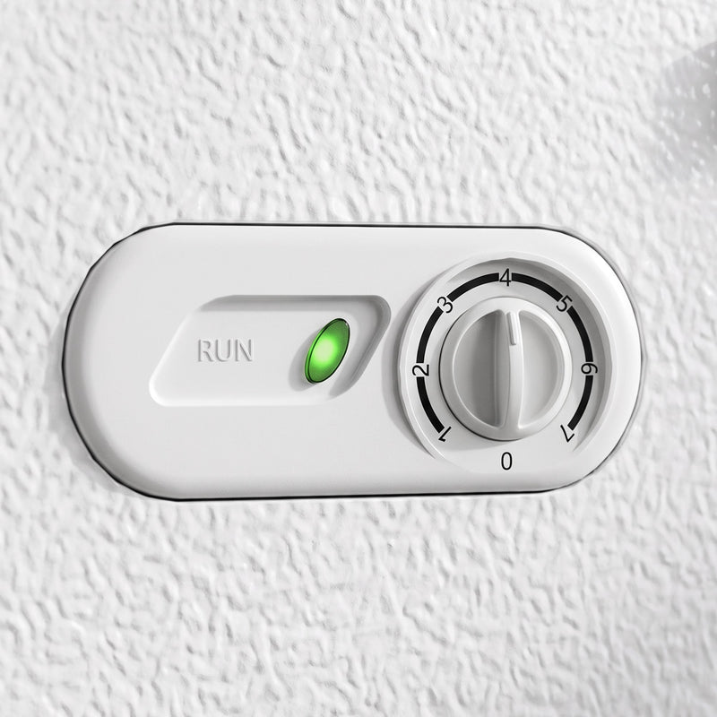 Close-up of the white chest freezer's temperature dial and green run indicator