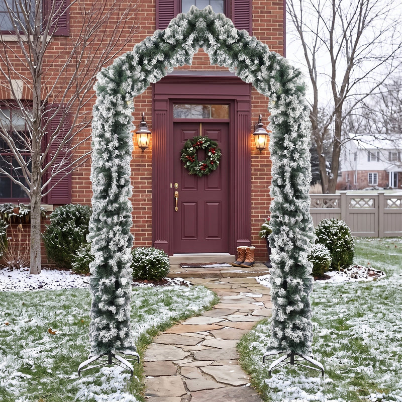 Flocked Christmas arch framing a red front door on a snowy path