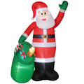 Inflatable Santa waving beside a green toy sack on a white background