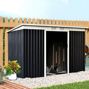The wide grey shed set against a wooden fence with its sliding doors open, showing rakes and garden tools inside