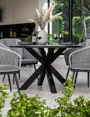 Aspen 120cm round ceramic dining table and grey rope chairs on a patio